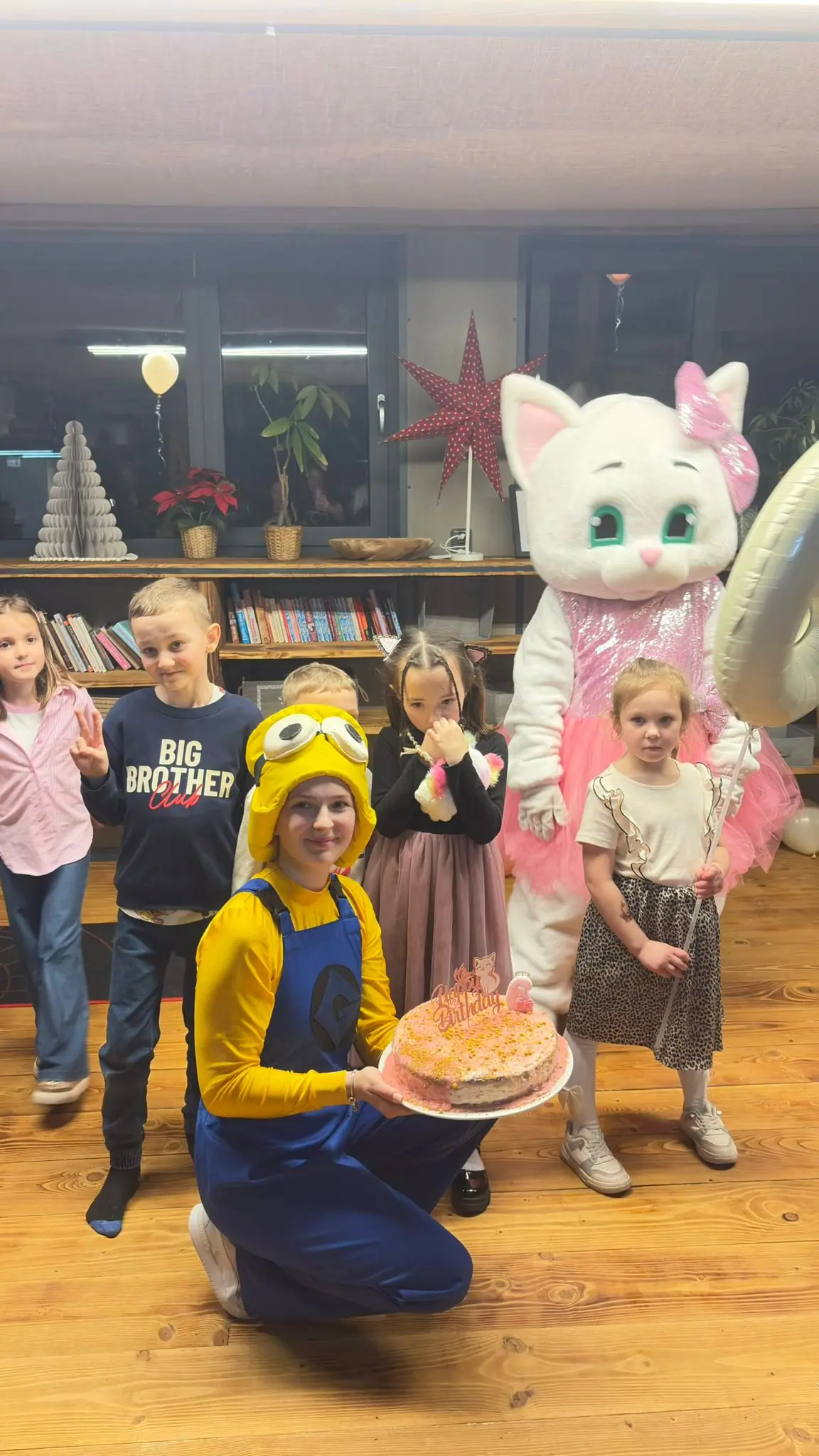 Skupina dětí s dortem a animátory v kostýmech